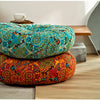 A vibrant orange and blue bohemian cotton linen throw cushion resting on a wooden surface.