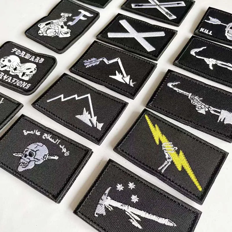 A collection of black embroidered patches featuring skull, pirate, and sword designs with hook and loop backing.