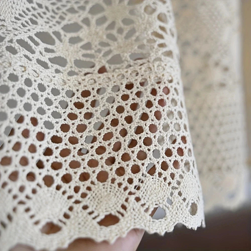 Close-up of a rustic crochet half curtain with linen weave in beige color.