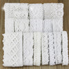 Roll of white cotton embroidered lace trim in various widths and patterns