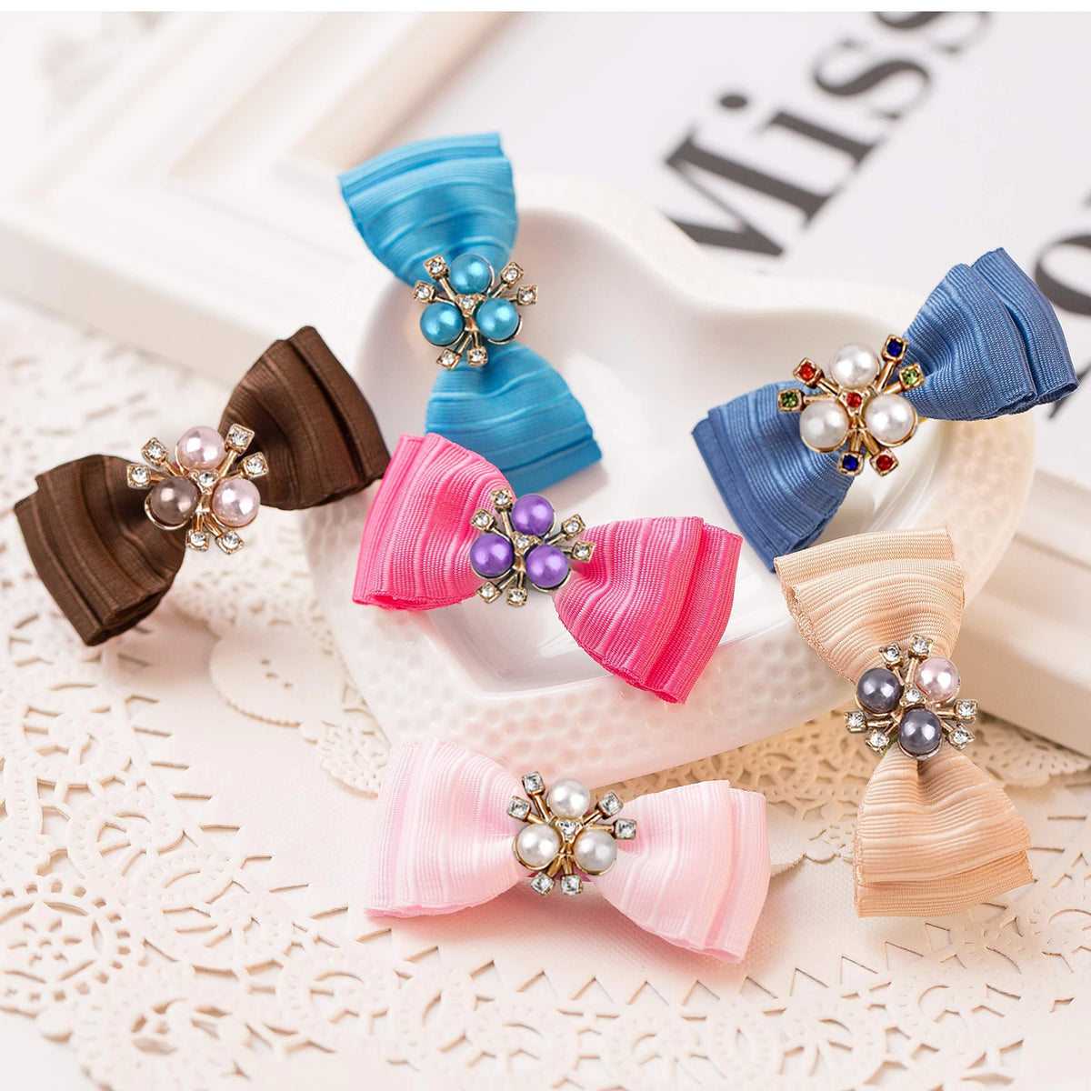 A set of flower-shaped resin buttons adorned with sparkling rhinestones in shades of blue, pink, and gold.