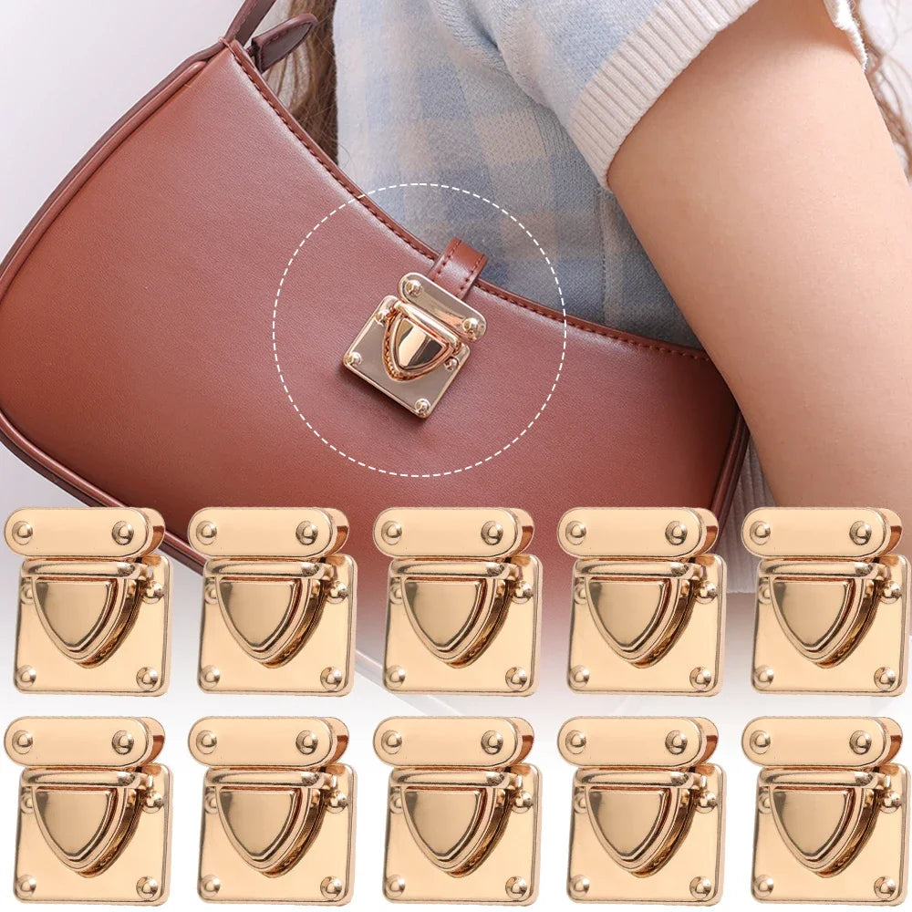 A set of gold-toned metal clasps and buckles for handbags shown on a brown leather purse.