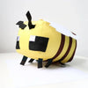 A yellow stuffed dragon plush toy with black and white markings.