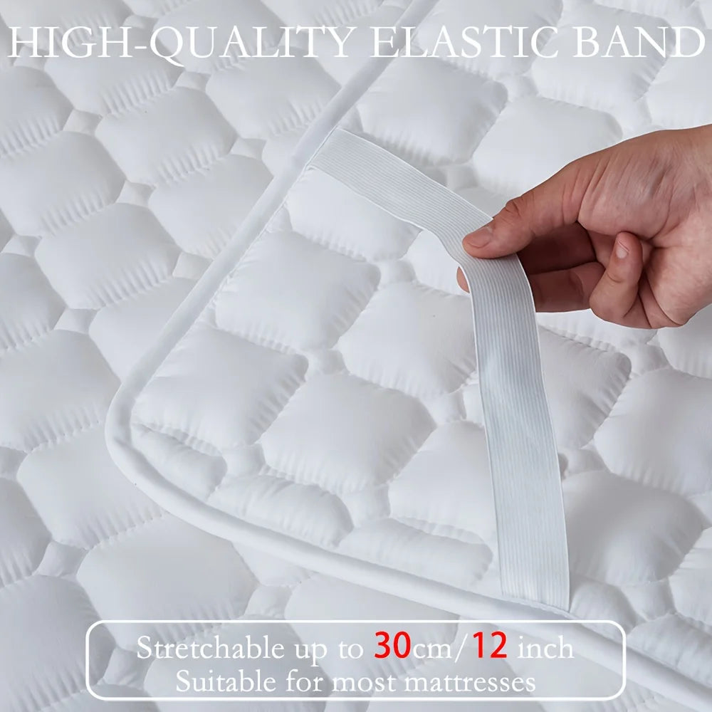 A hand is stretching a high-quality elastic band on a white quilted mattress protector.