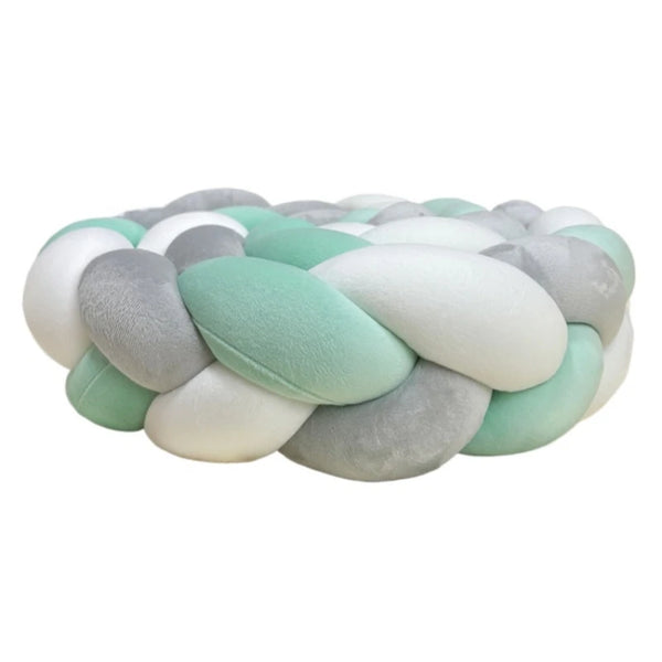 A handmade knotted floor mat for bed decor featuring interwoven soft pastel colors like mint green, gray, and white.