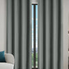 Gray blackout window curtains hanging in a doorway with a view outside