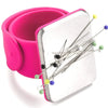A pink silicone band holds a silver magnetic pincushion with several pins and colored tips.