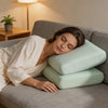 A woman rests her head on a light green ice silk cooling pillowcase while relaxing on a gray sofa.