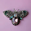 Handmade bee beaded sew-on patches featuring iridescent green and silver sequins on a purple background.