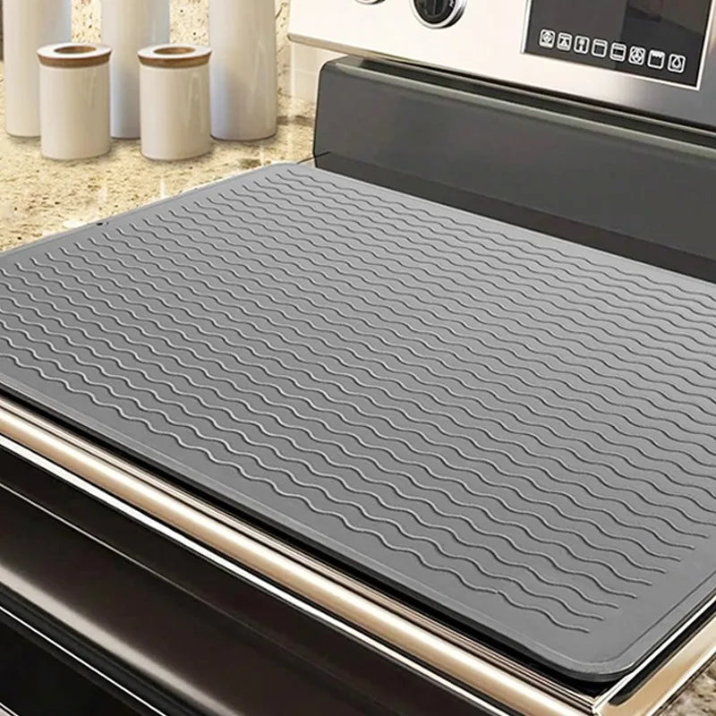 A gray heat-resistant silicone stove top cover mat placed inside an oven or appliance.