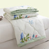 A stack of white quilted duvet covers featuring light blue and green floral embroidery.