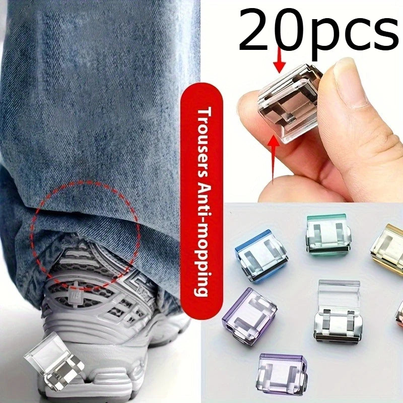 A hand holds several clear and translucent invisible hem shortening clips for clothing.