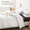 A set of three plaid duvet covers and pillowcases displayed on a bed with white bedding.