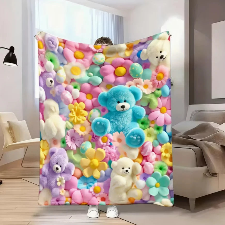A colorful flannel blanket featuring a floral print with various teddy bears and flowers.