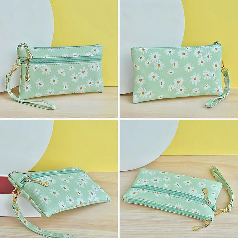 A light green PU leather coin purse with a white and orange daisy floral pattern shown in multiple angles.