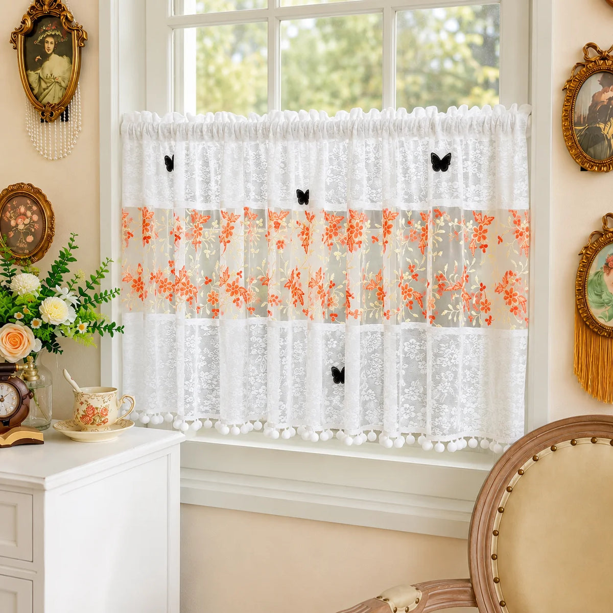 White lace cafe curtain with orange floral embroidery and black butterfly appliqués hanging in a window.