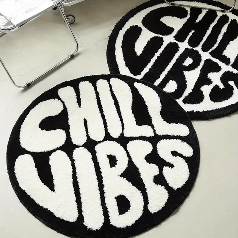 Black and white fuzzy round rug with the text CHILL VIBES in white lettering