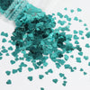 A pile of teal green heart-shaped glitter filler for epoxy art
