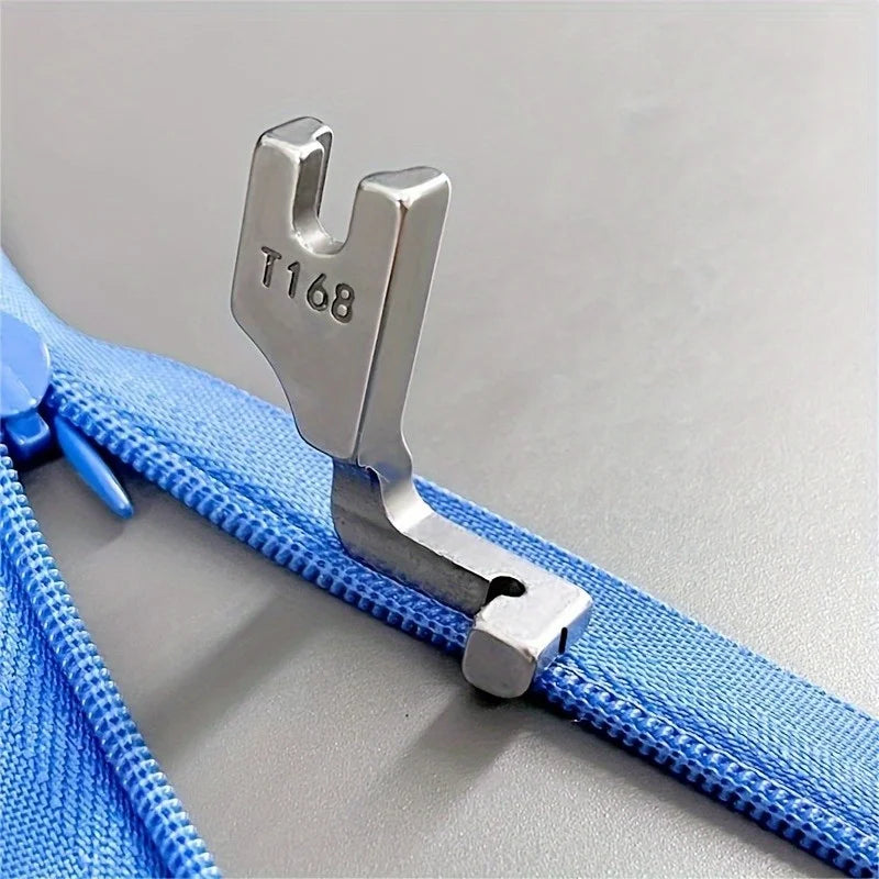 Silver industrial steel presser foot with a T168 marking attached to a blue fabric zipper.