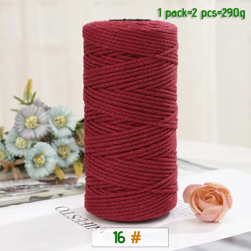 A roll of medium-thick, hand-woven cotton yarn in a deep reddish-pink color for crafting.