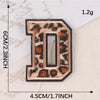 A leopard print iron-on patch shaped like the letter D, measuring 1.2 grams and 4.5 cm tall.