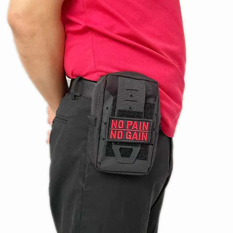 A close-up of a black hook and loop patch with red text reading NO PAIN NO GAIN sewn onto a pink shirt.