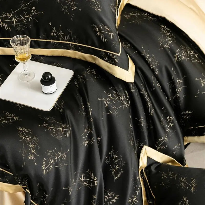 Black luxury lyocell eucalyptus bedding set with gold trim and a glass of amber liquid