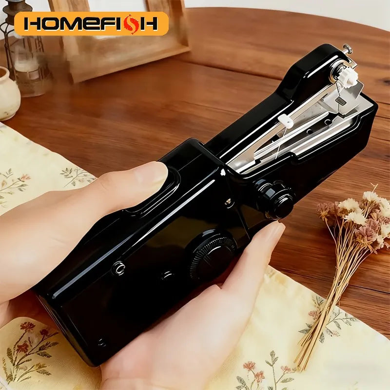A hand is holding a black compact handheld electric sewing machine on a wooden surface.