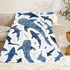 A patterned blanket featuring a watercolor blue whale shark design on a white background.