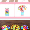 A colorful bouquet of felt flowers in various shades of pink, yellow, and green.