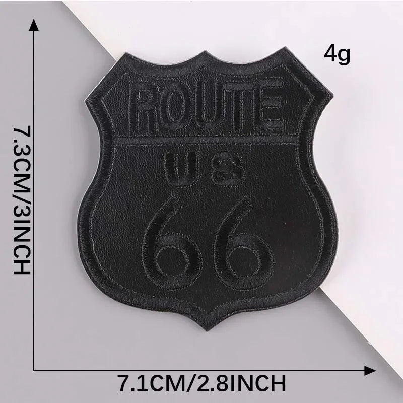 A black embroidered leather patch with the text ROUTE US 66 on it, shown against a white background.