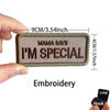 A close-up of a brown embroidered patch that says Mama Says I'm Special, shown being held by a hand.
