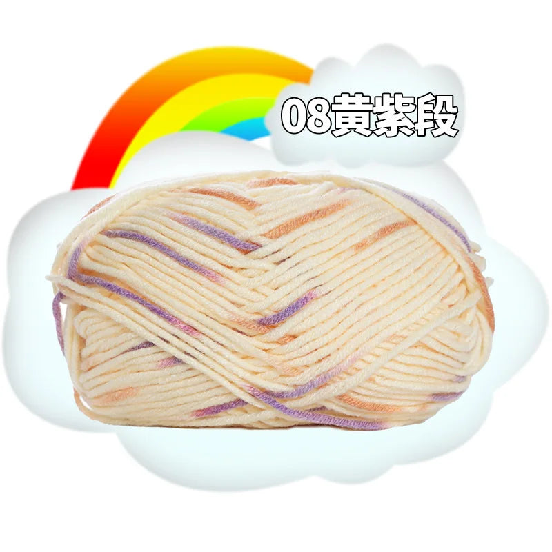 A ball of light beige premium milk cotton yarn with purple accents is shown next to a rainbow graphic.