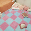 Pink and blue checkered play mat tiles with soft plush toys and a large pink bed.