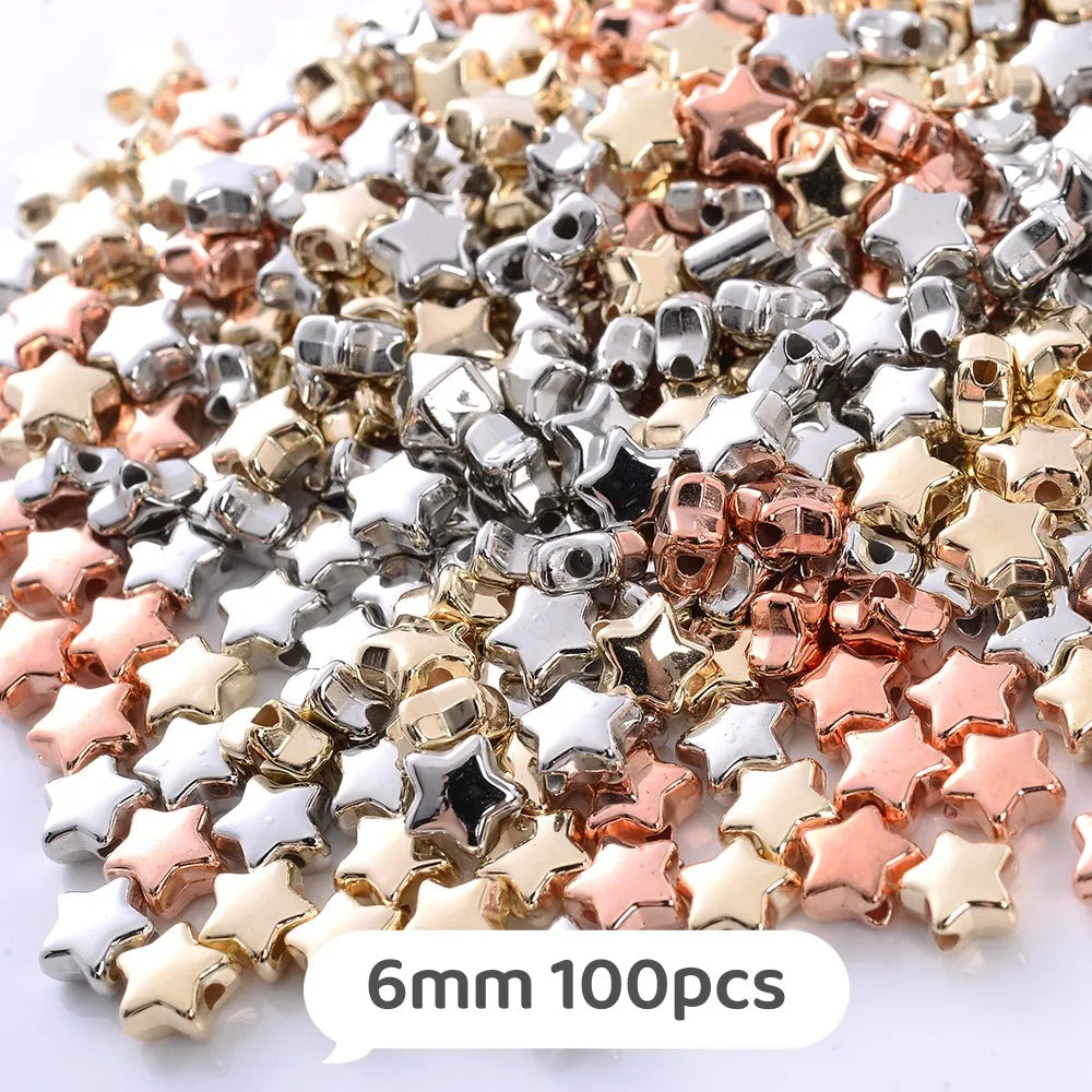 A pile of small, colorful geometric acrylic star beads in silver, gold, and rose gold tones.