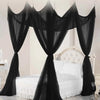Elegant black mosquito netting canopy draped over a white bed.