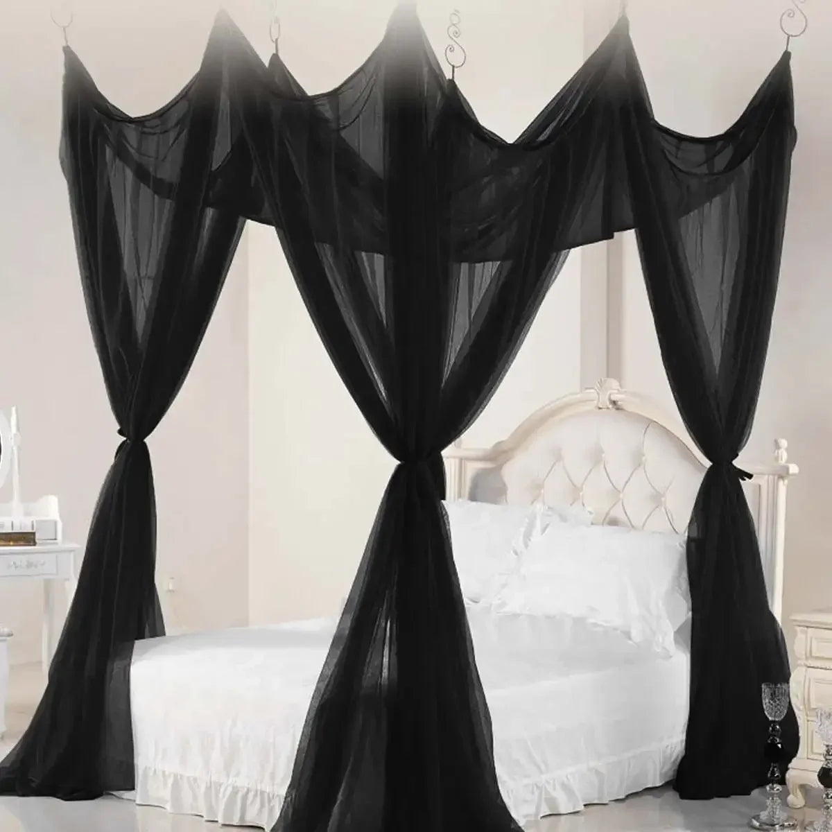 Elegant black mosquito netting canopy draped over a white bed.
