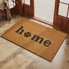 A rectangular, tan coconut fiber doormat with the word home printed in dark lettering placed on a light wood floor near a gla