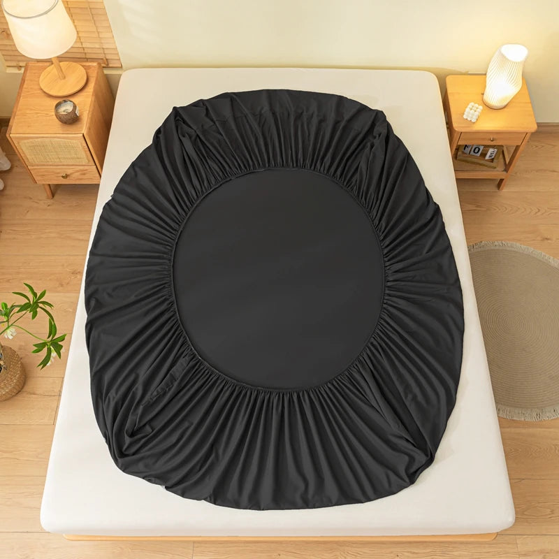 A black brushed elastic fitted bed sheet is displayed on a white bed frame.