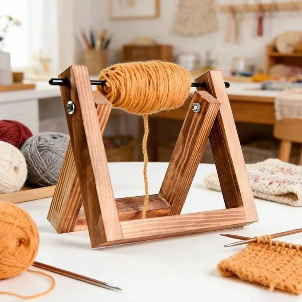 A wooden rotating yarn storage rack holds a ball of golden yellow yarn on a white surface.