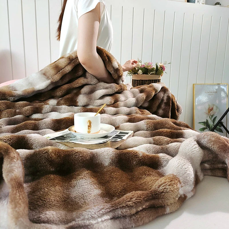 A plush brown and beige rabbit fur throw blanket draped over a white surface with a cup and saucer.
