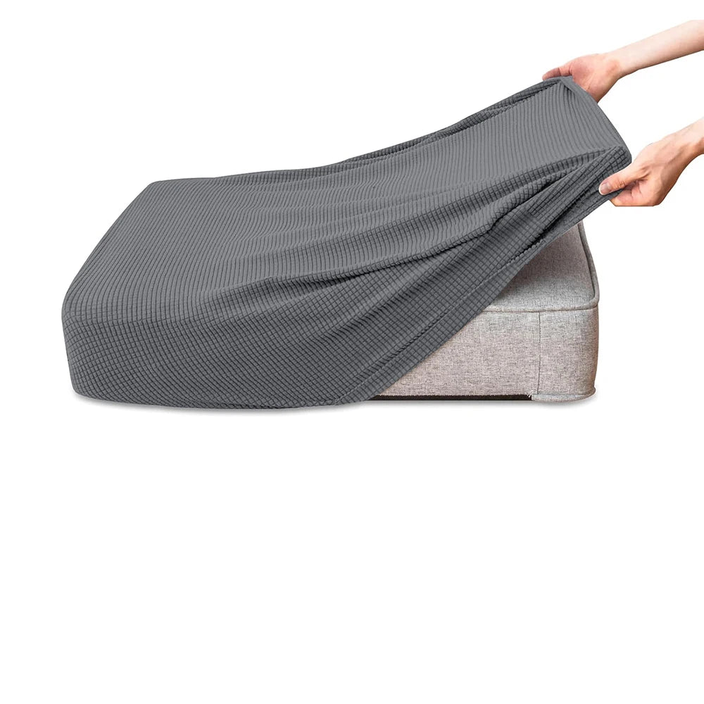 A dark gray polar fleece jacquard sofa seat cushion cover being held by a hand.