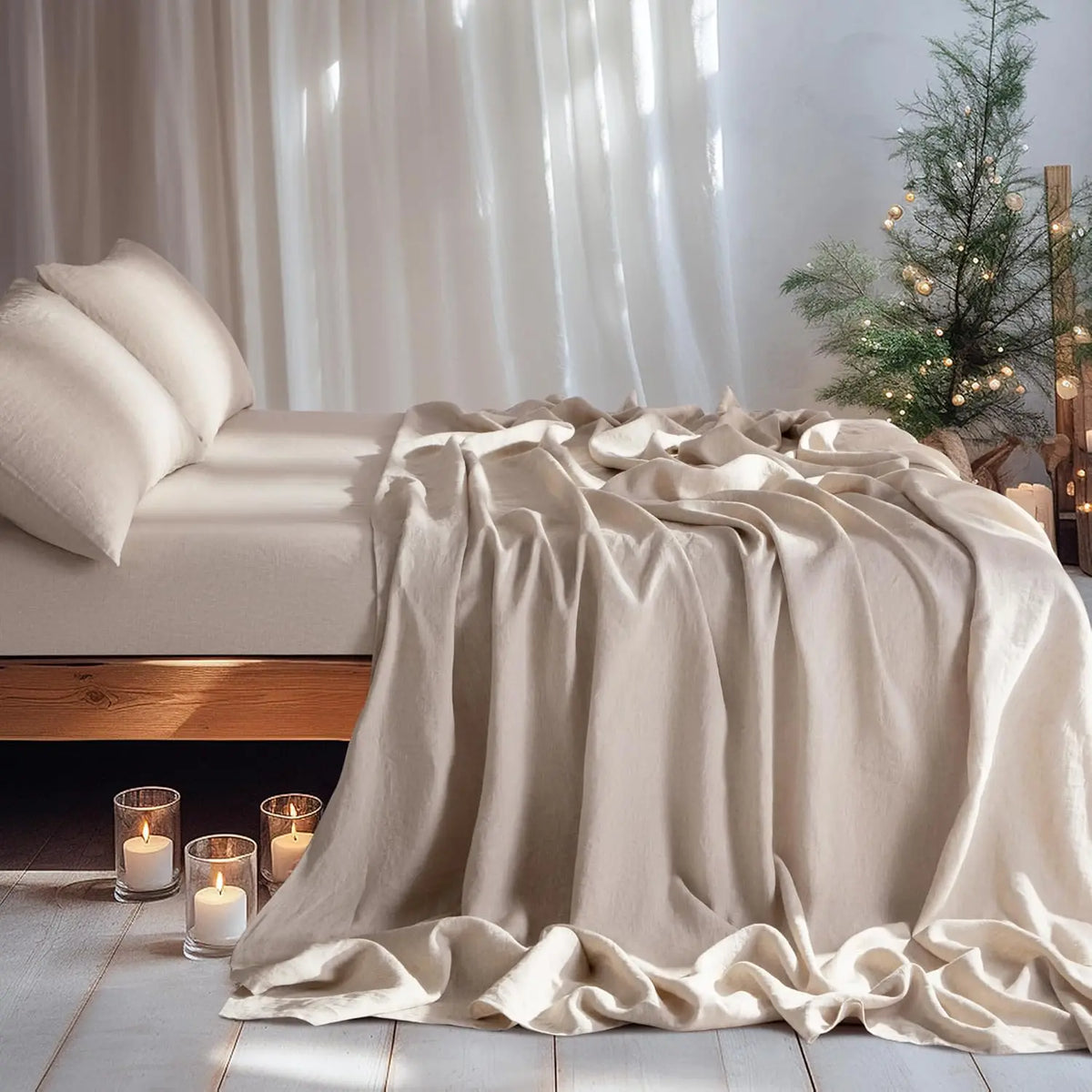 A beige linen duvet and pillows are draped on a bed, illuminated by candles in a bright room.