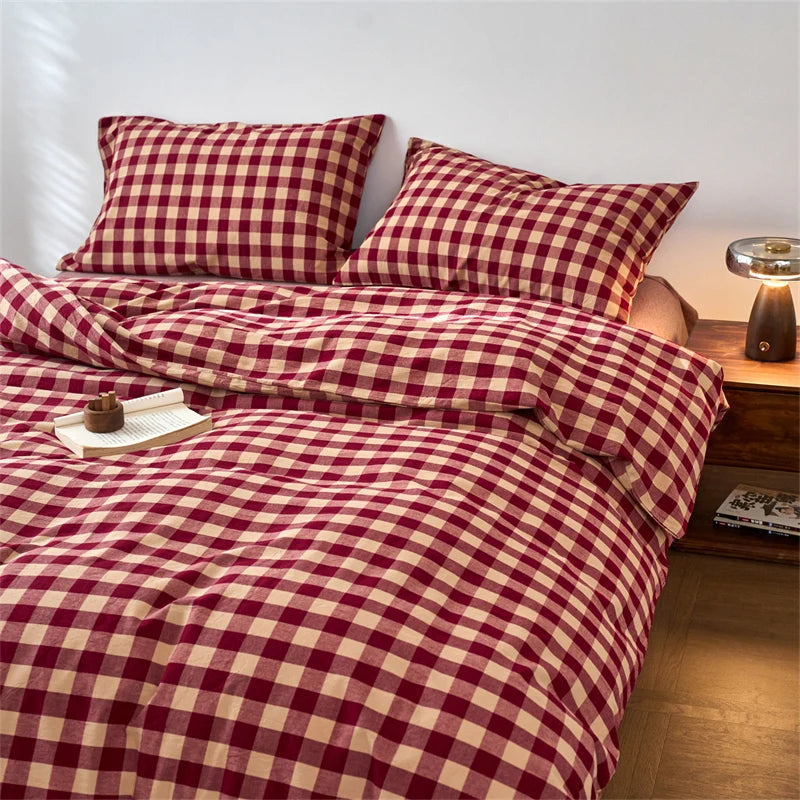 A close-up of a red and cream plaid duvet cover set with matching pillows on a bed.