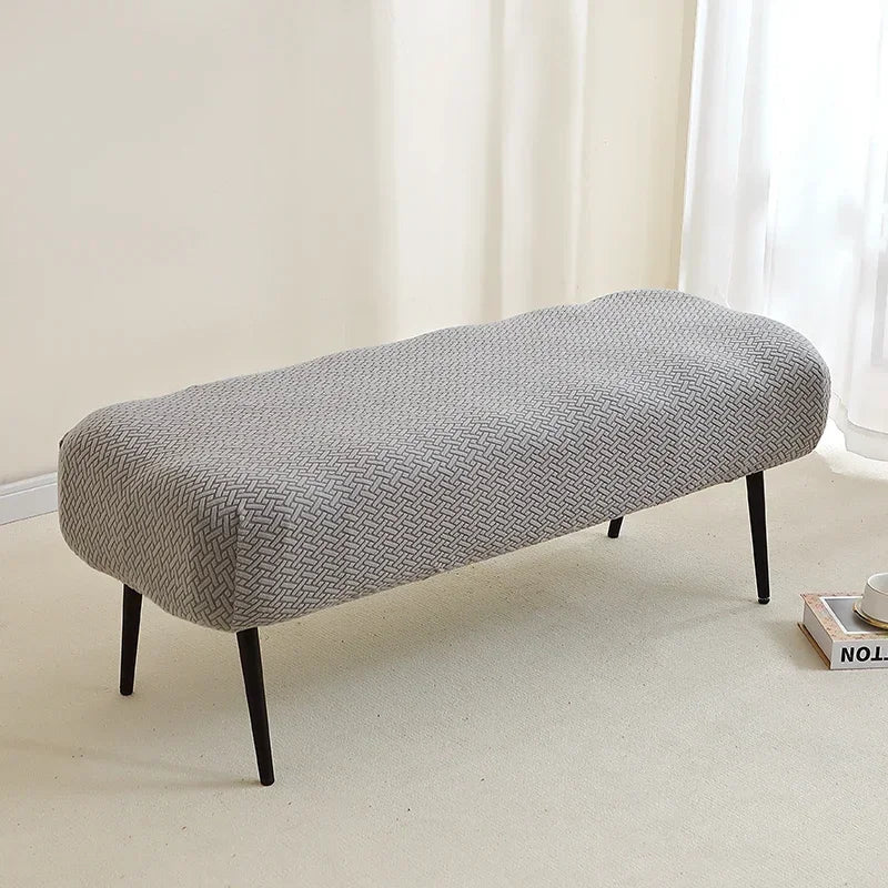 A gray elastic jacquard bench cover used as protection for a piano, dining, or entryway seat.