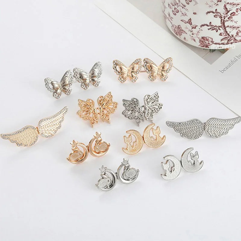 A collection of adjustable button clips in gold and silver tones, shaped like butterflies and moons.