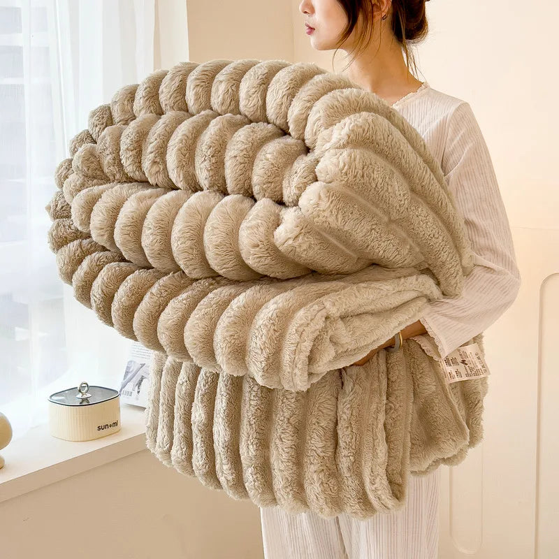 A woman holds a thick, beige faux fur blanket with vertical stripes in a soft, natural light.