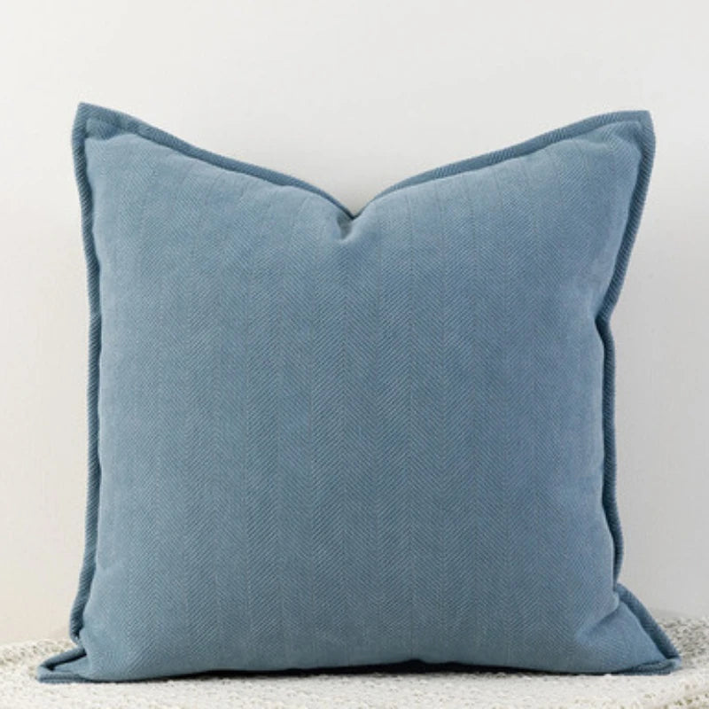 A solid blue-gray chenille throw pillow with a subtle vertical stripe texture.