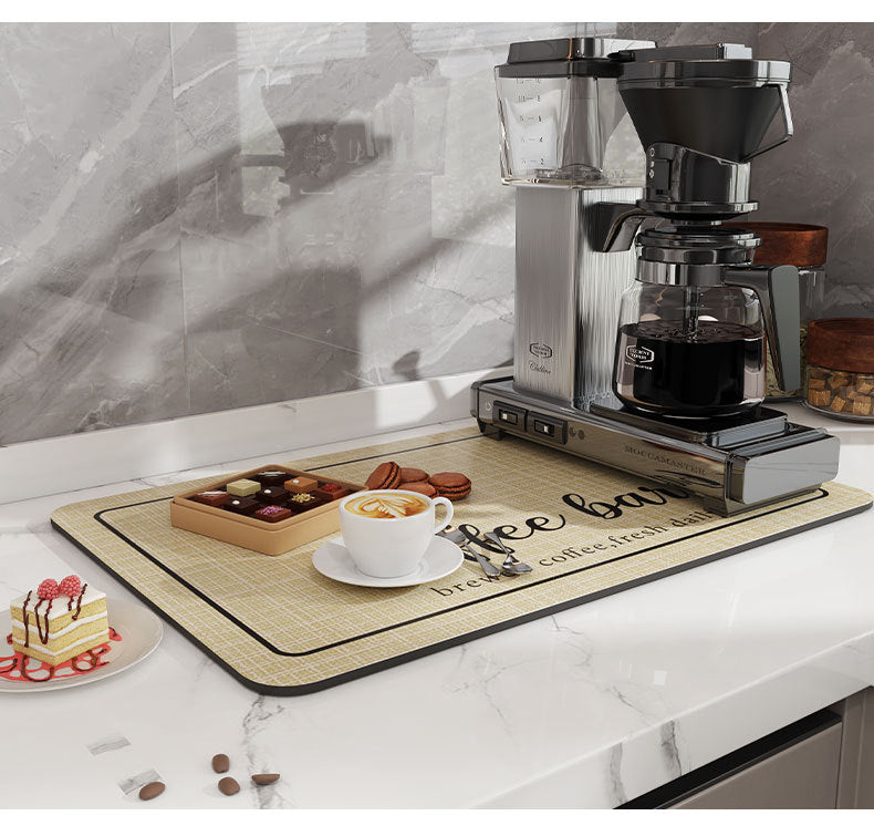 A silver electric coffee grinder and a wooden mat are displayed on a white countertop.