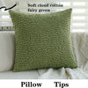 A soft cloud cotton fairy green pillow with a textured fabric resting on a light-colored sofa.